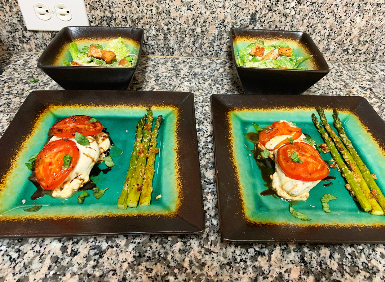 A treat for two: Caprese Roasted Chicken Breasts with Honey Balsamic Reduction, Garlic-Parmesan Roasted Asparagus, and Caesar Salad with homemade caesar dressing and ciabatta croutons.